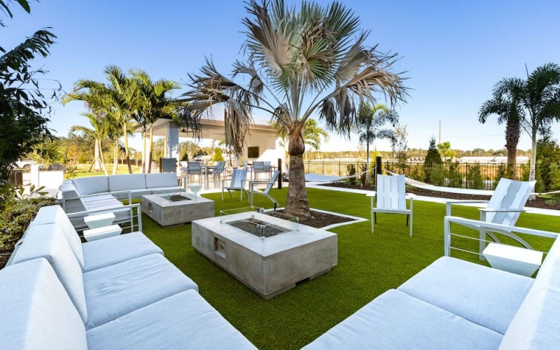 outdoor lounge area with green turf and tropical landscaping