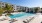 pool with reclining seats and lush landscaping